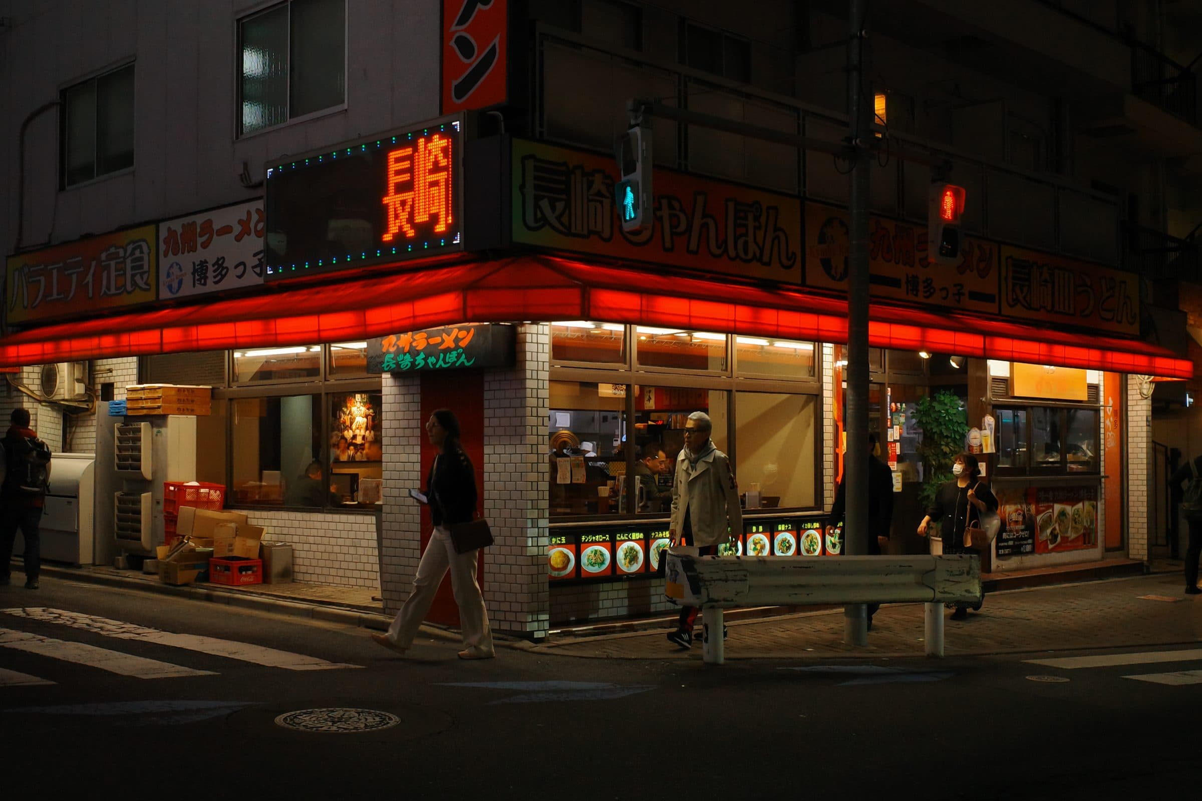 A ramen restaurant on a street corner in Tokyo at night