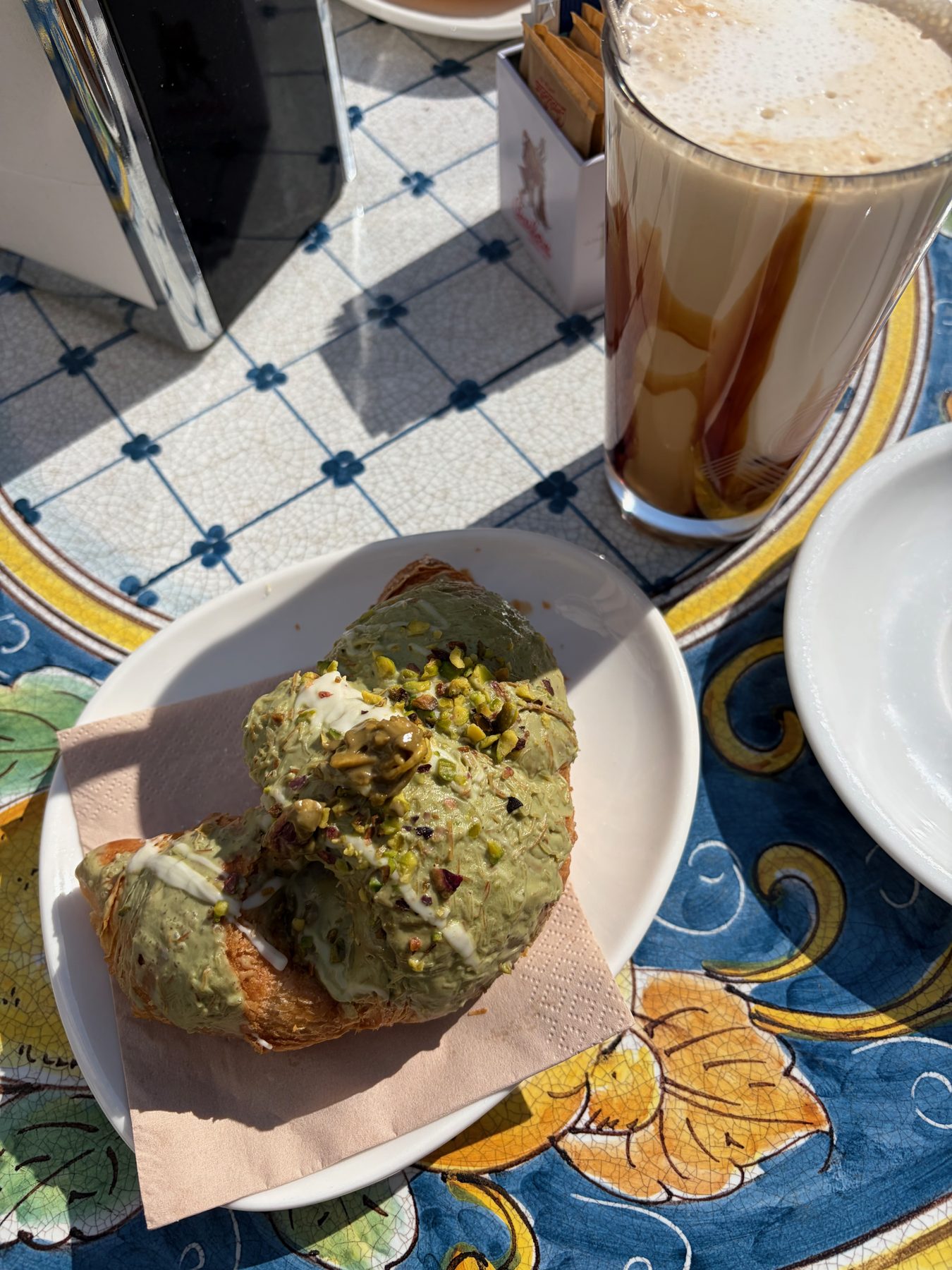 Coffee and a pistachio croissant in front of the cathedral