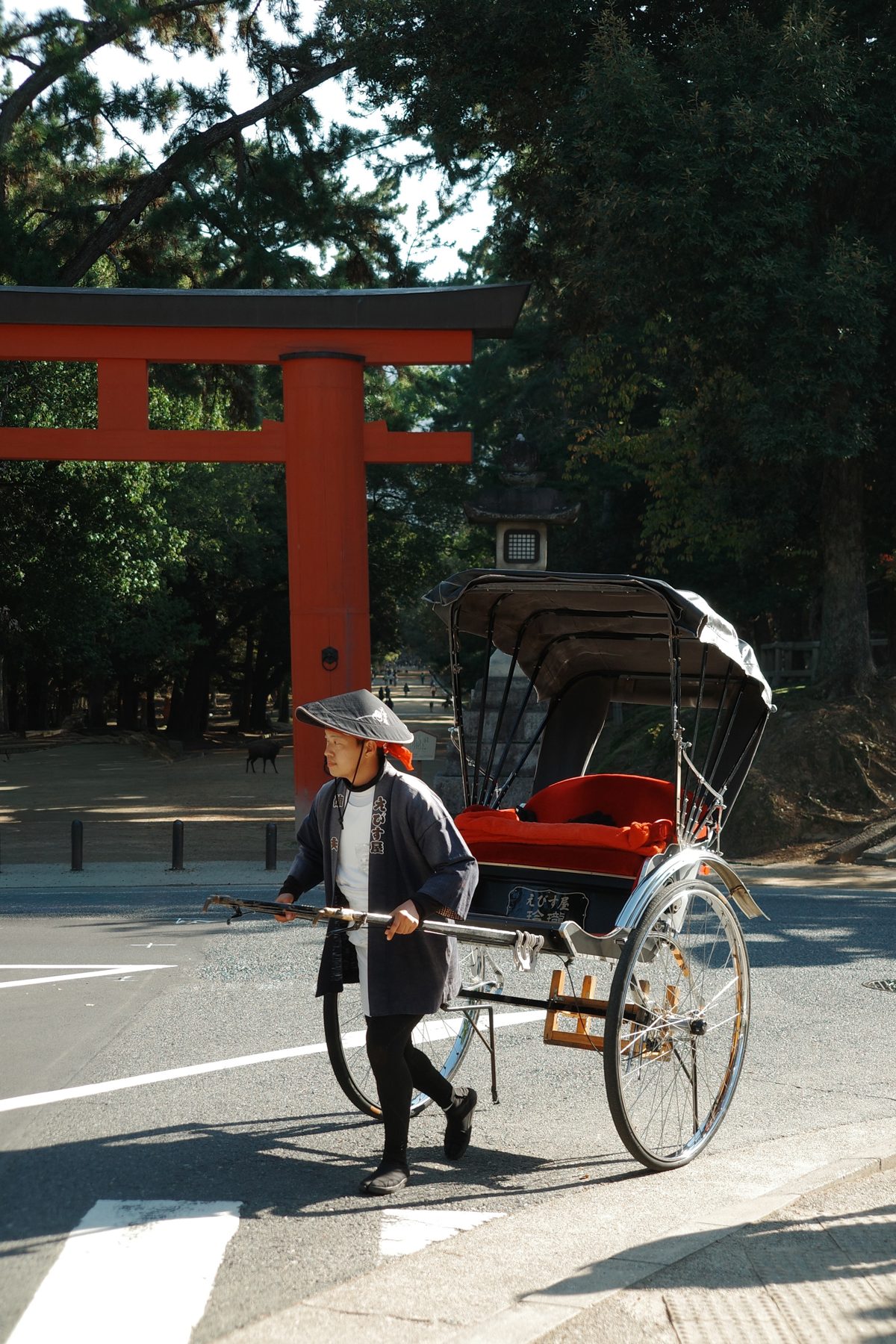A rickshaw passing a torii
