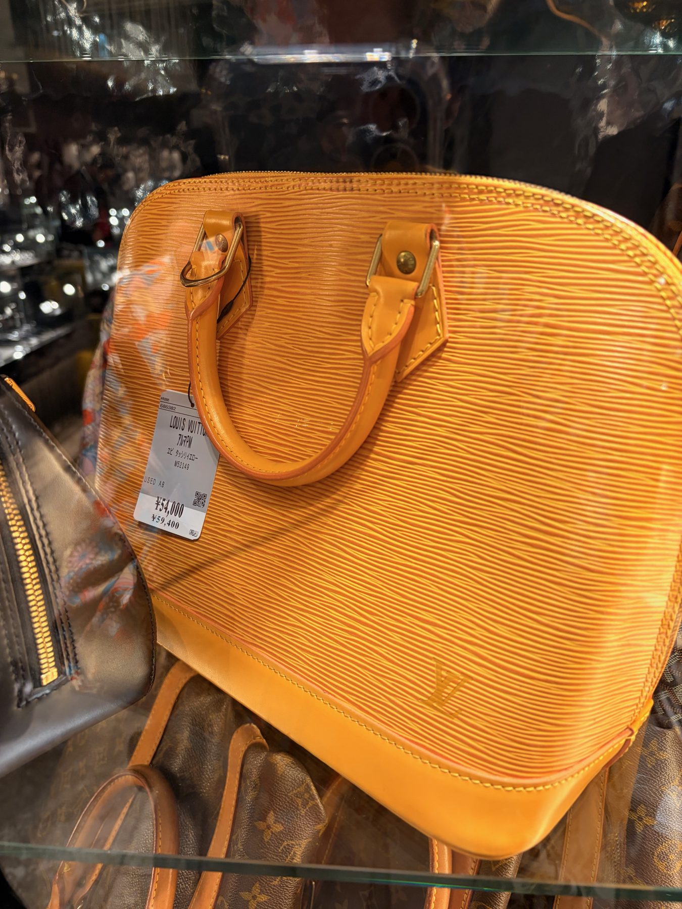 A Louis Vuitton Alma in Epi leather, with its price tag