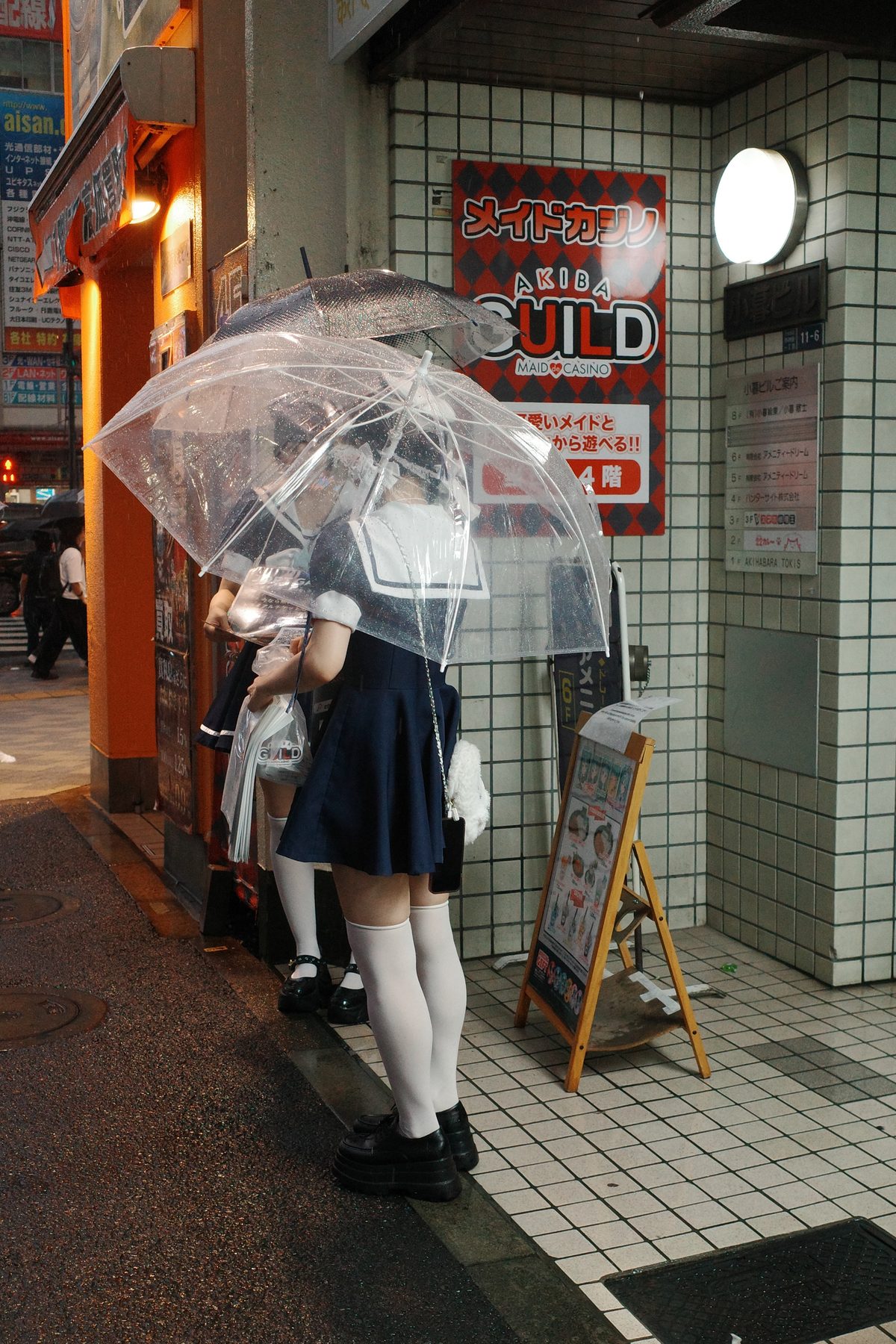 A girl in a maid uniform under an umbrella