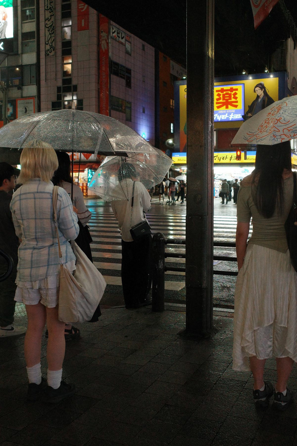 People waiting at a crossing at night