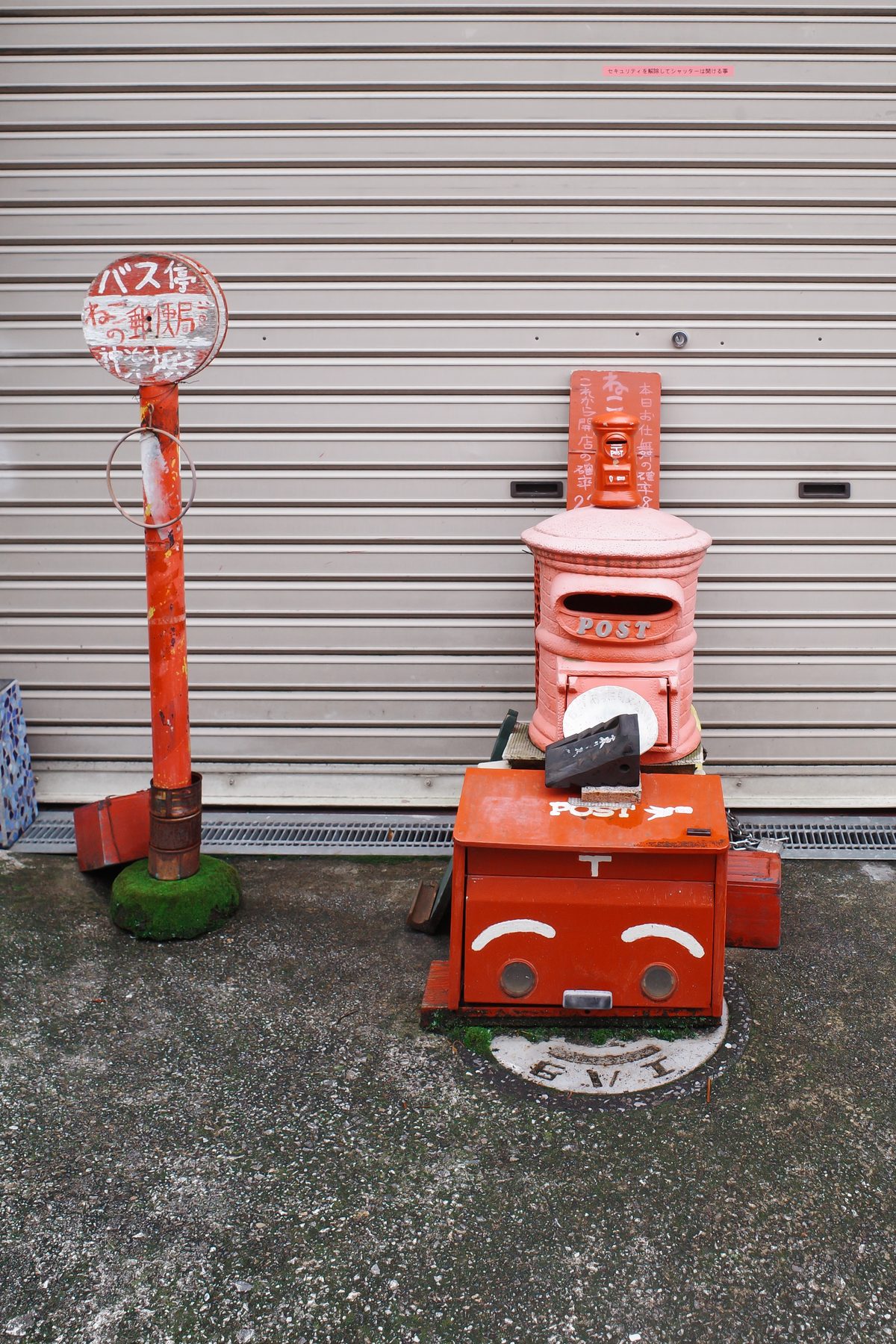 A red postbox and bus stop