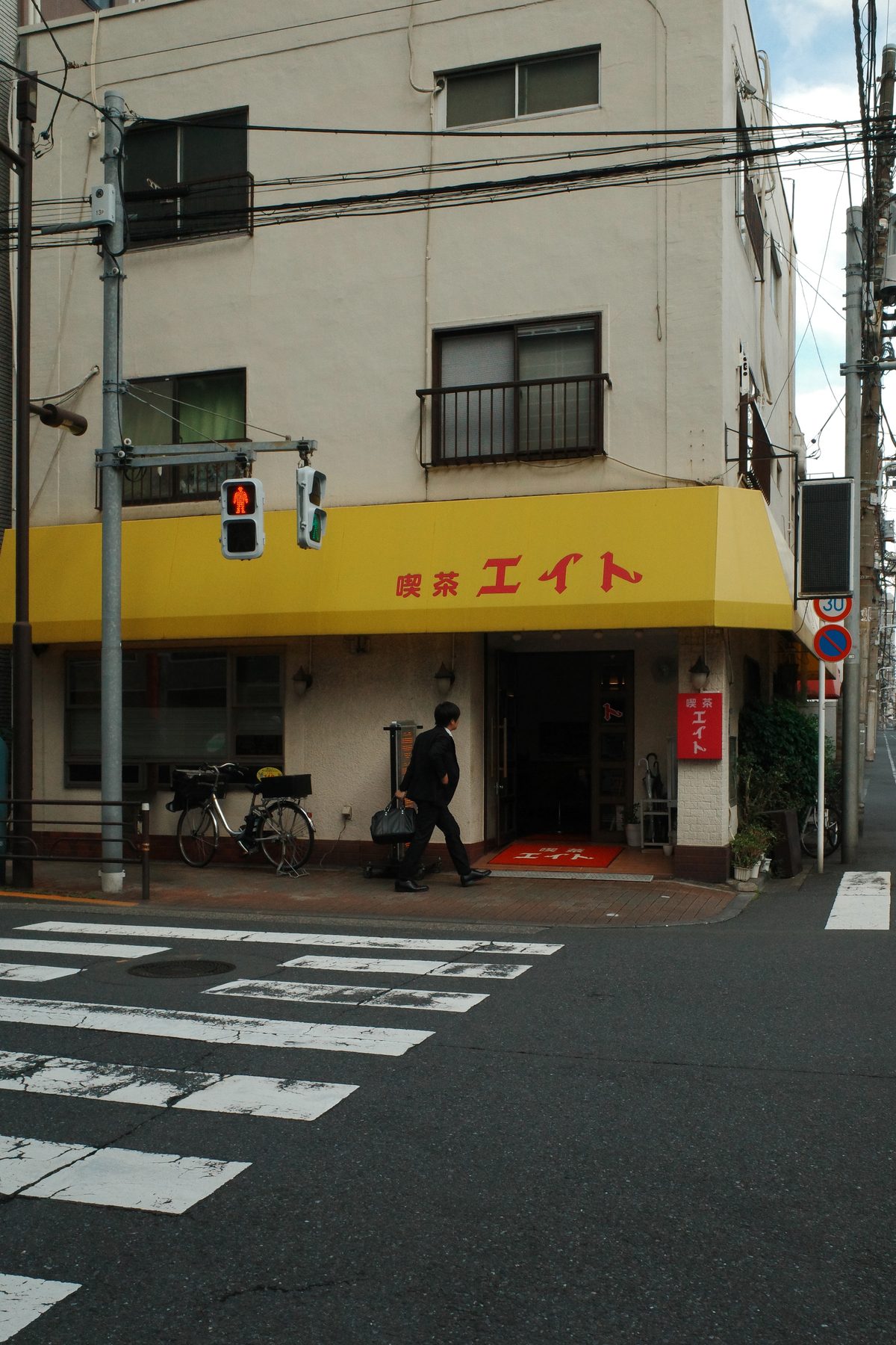 A café with a yellow awning on a corner