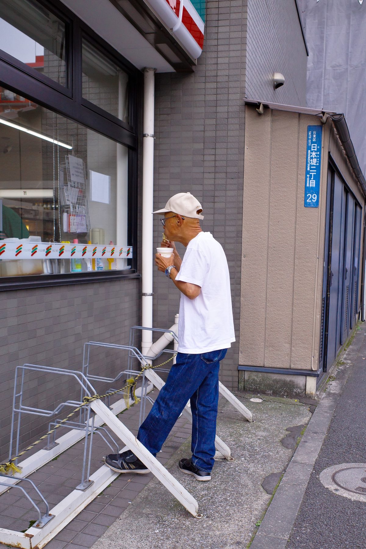 A man with his coffee outside a konbini