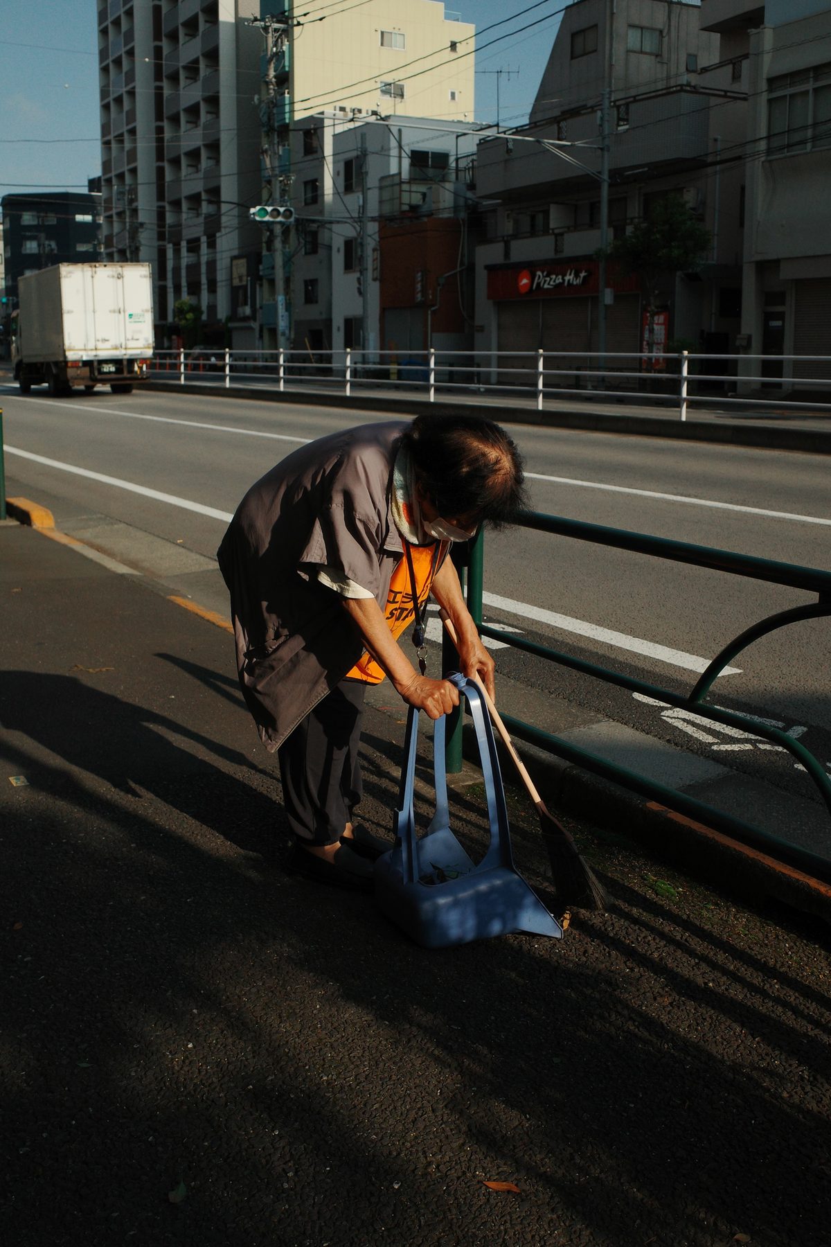 A woman picking up her things by the road