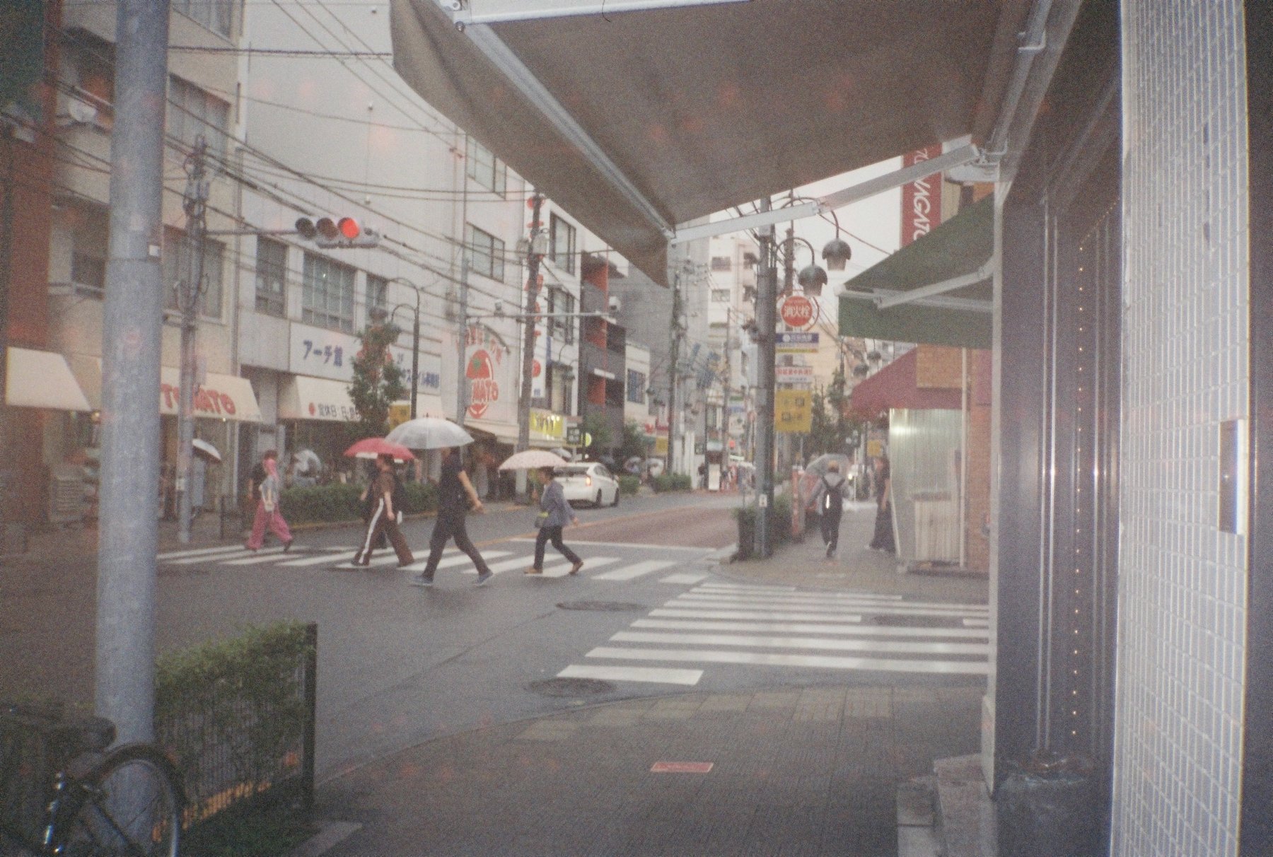 Umbrellas crossing the street in the fabric district