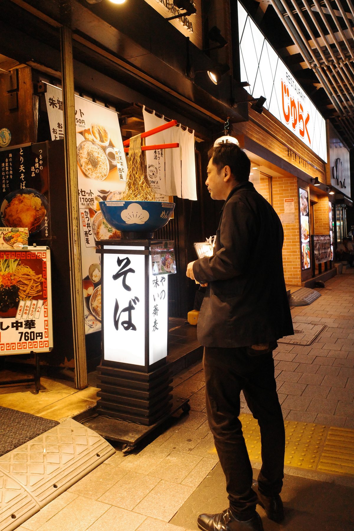 A man in front of a soba restaurant