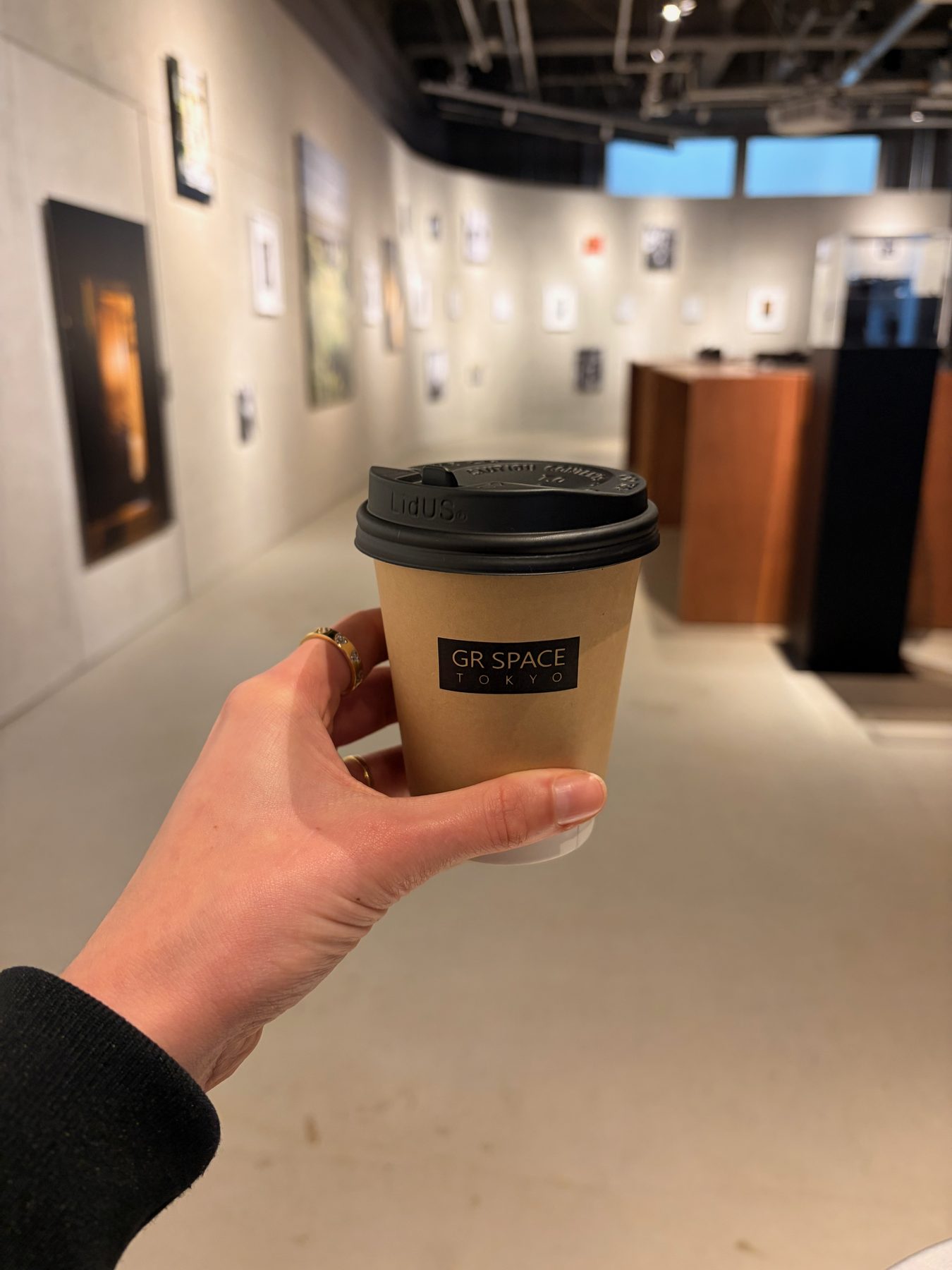 A coffee cup at GR Space Tokyo, with the gallery behind