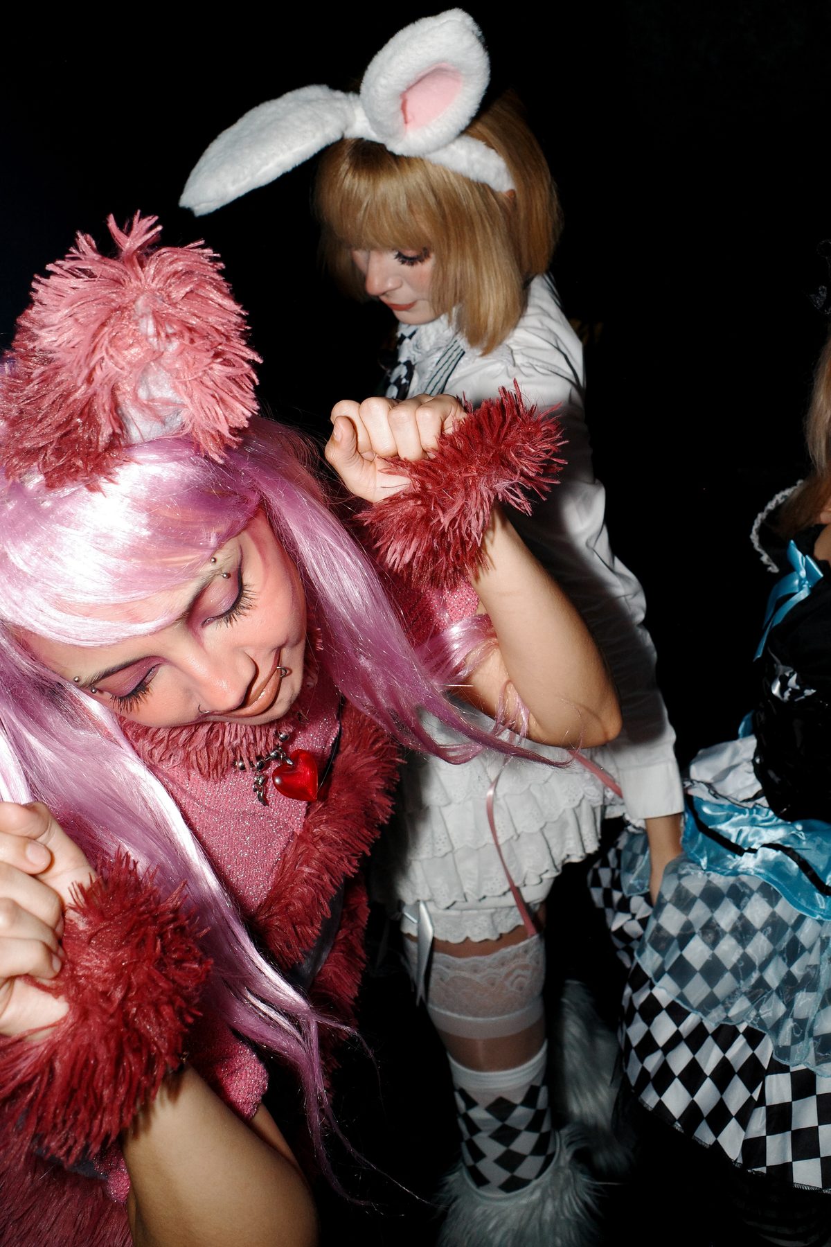 Two women in Halloween costumes, one in pink, one with bunny ears