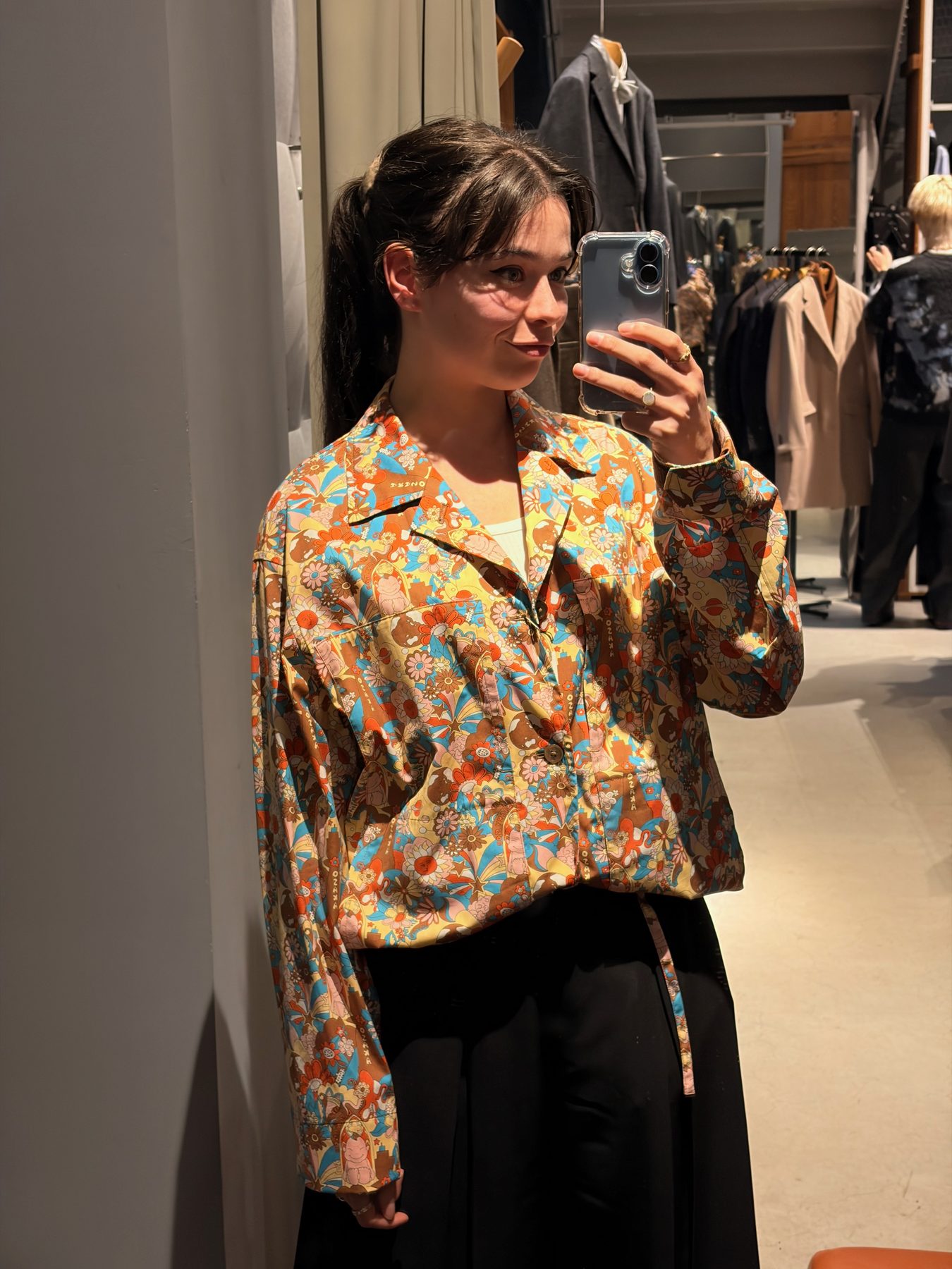 Trying a printed shirt in a shop mirror