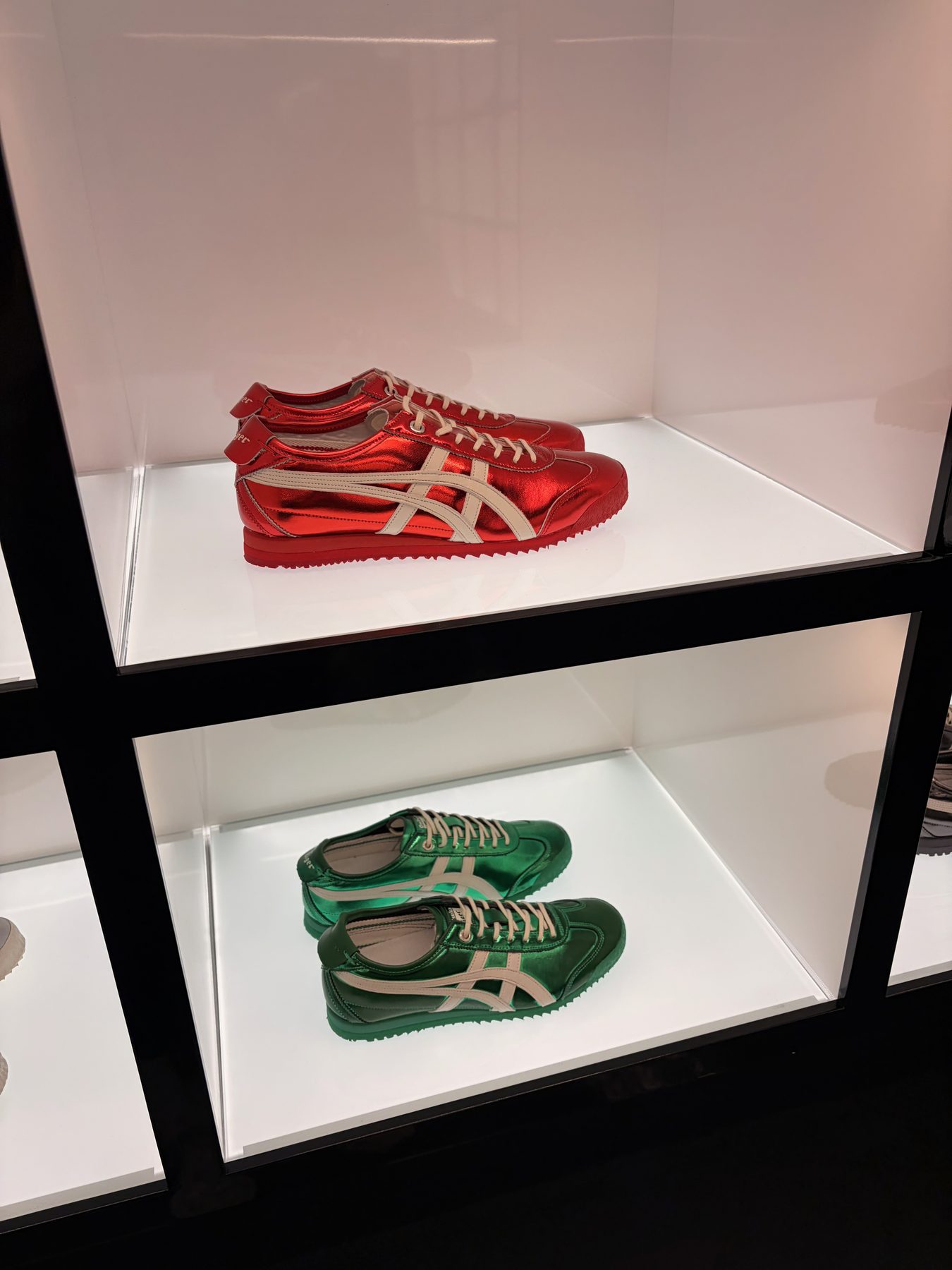 Red and green sneakers on display shelves