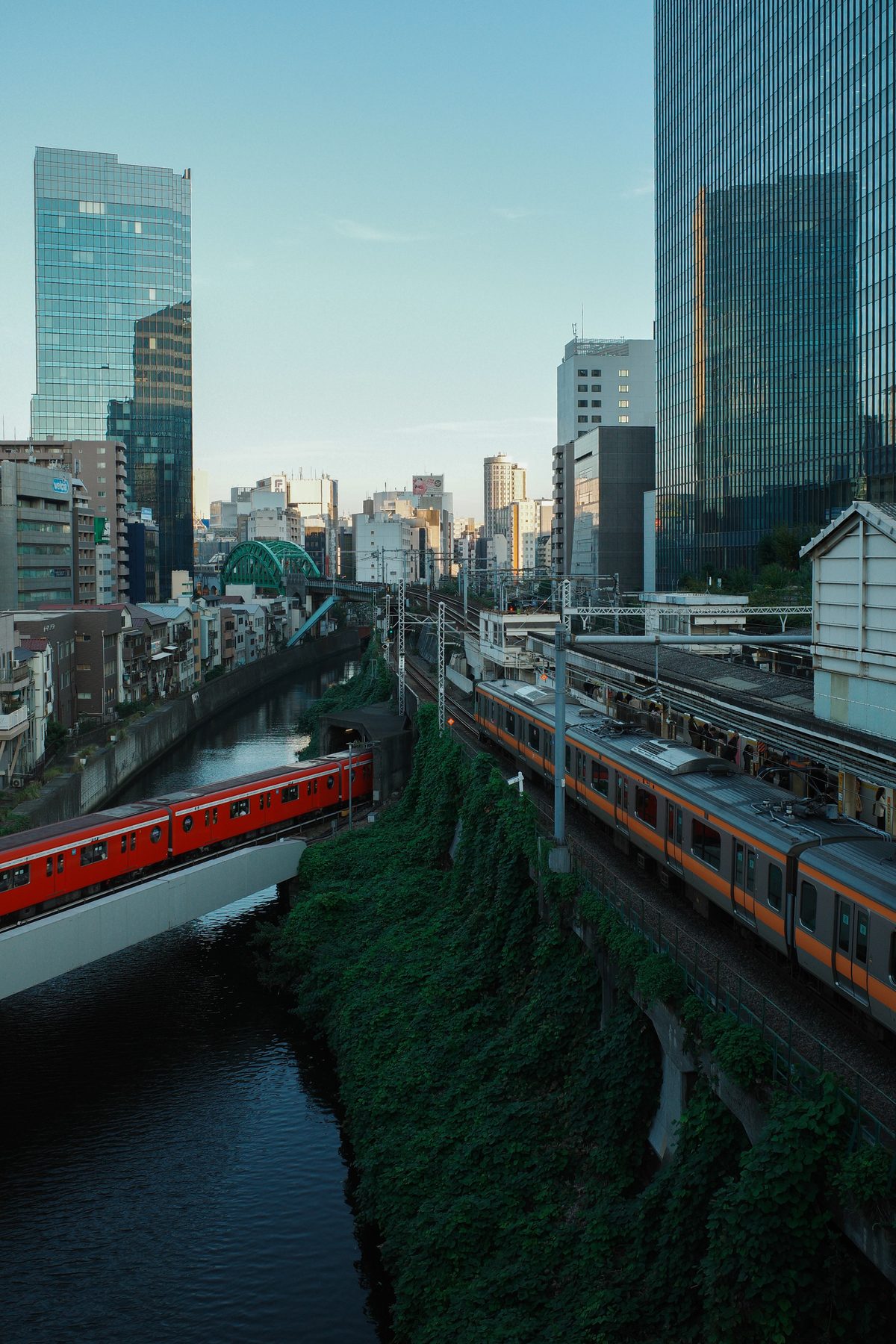 Two trains crossing above a river between towers