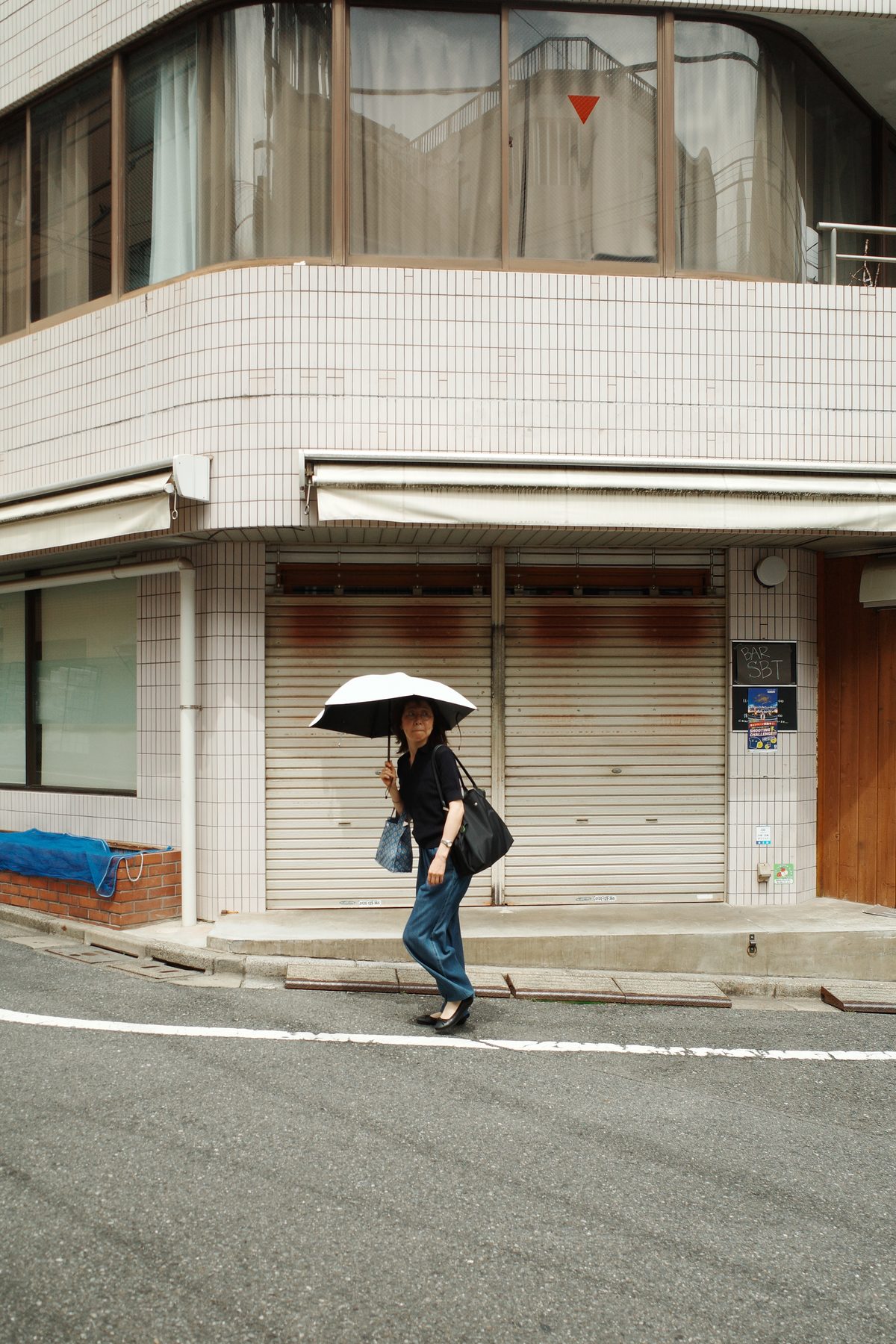 A woman with a parasol on a corner