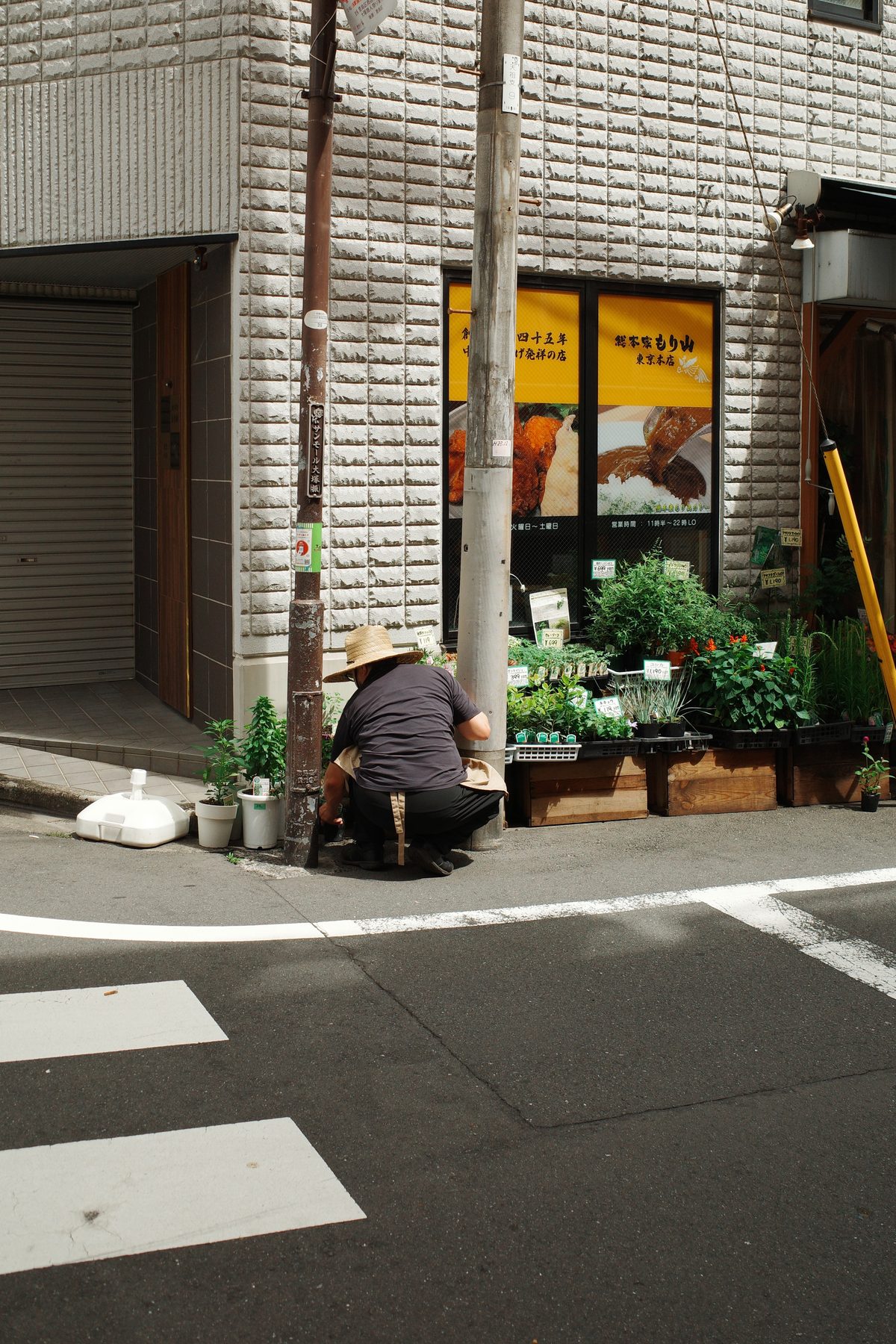 A man tending plants outside a shop