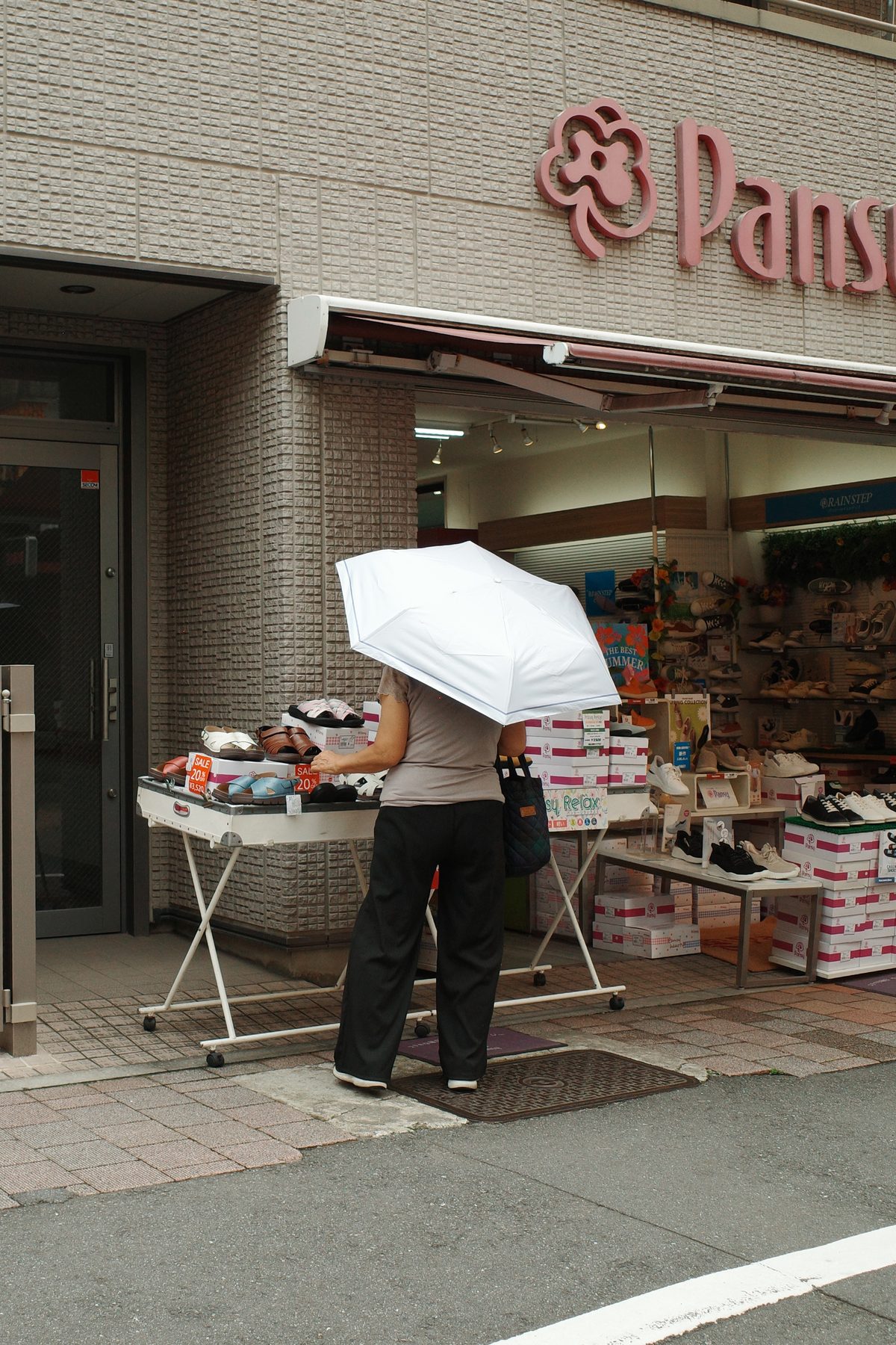 A woman with a parasol at a shop