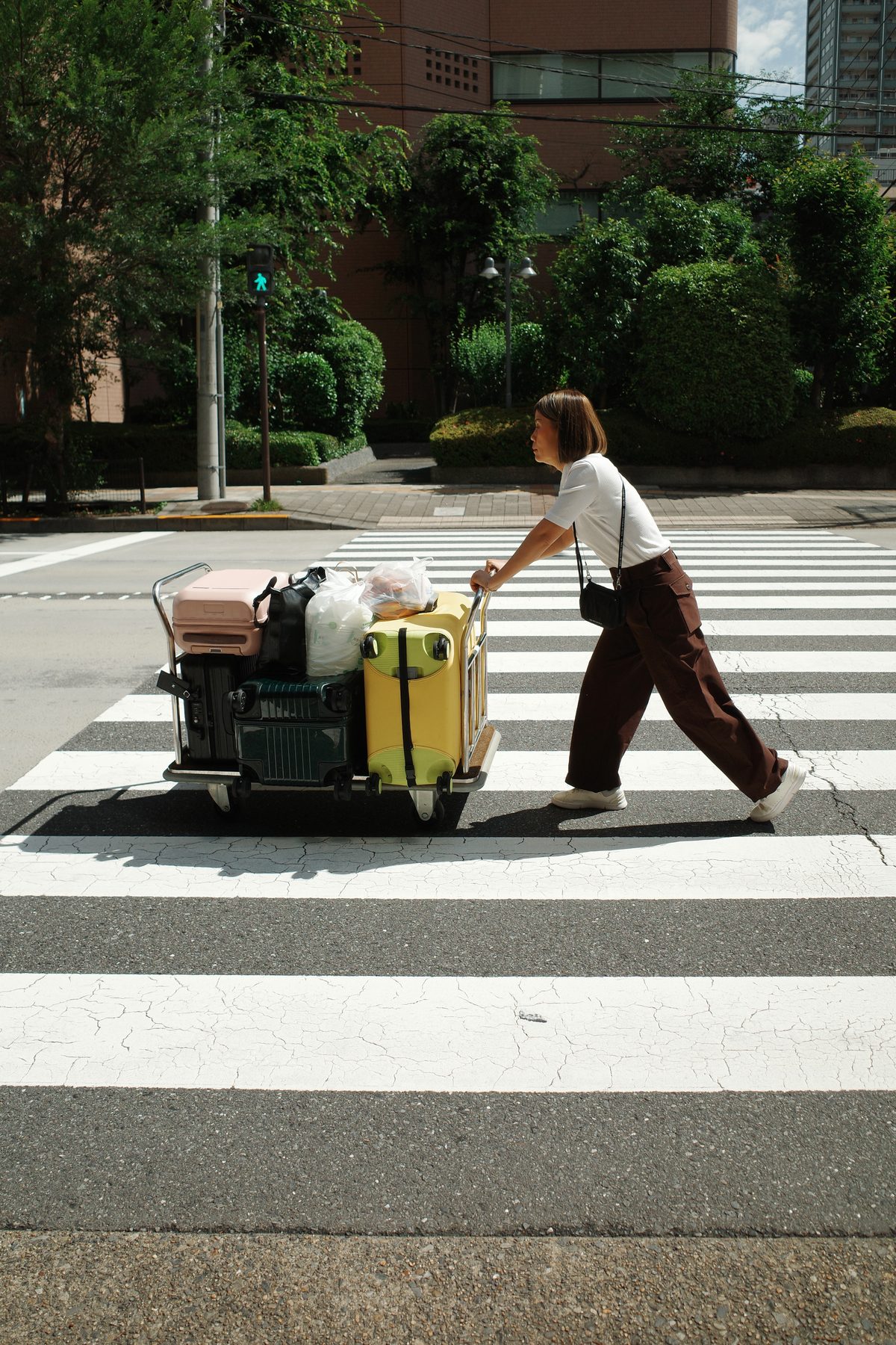 A woman crossing with her luggage