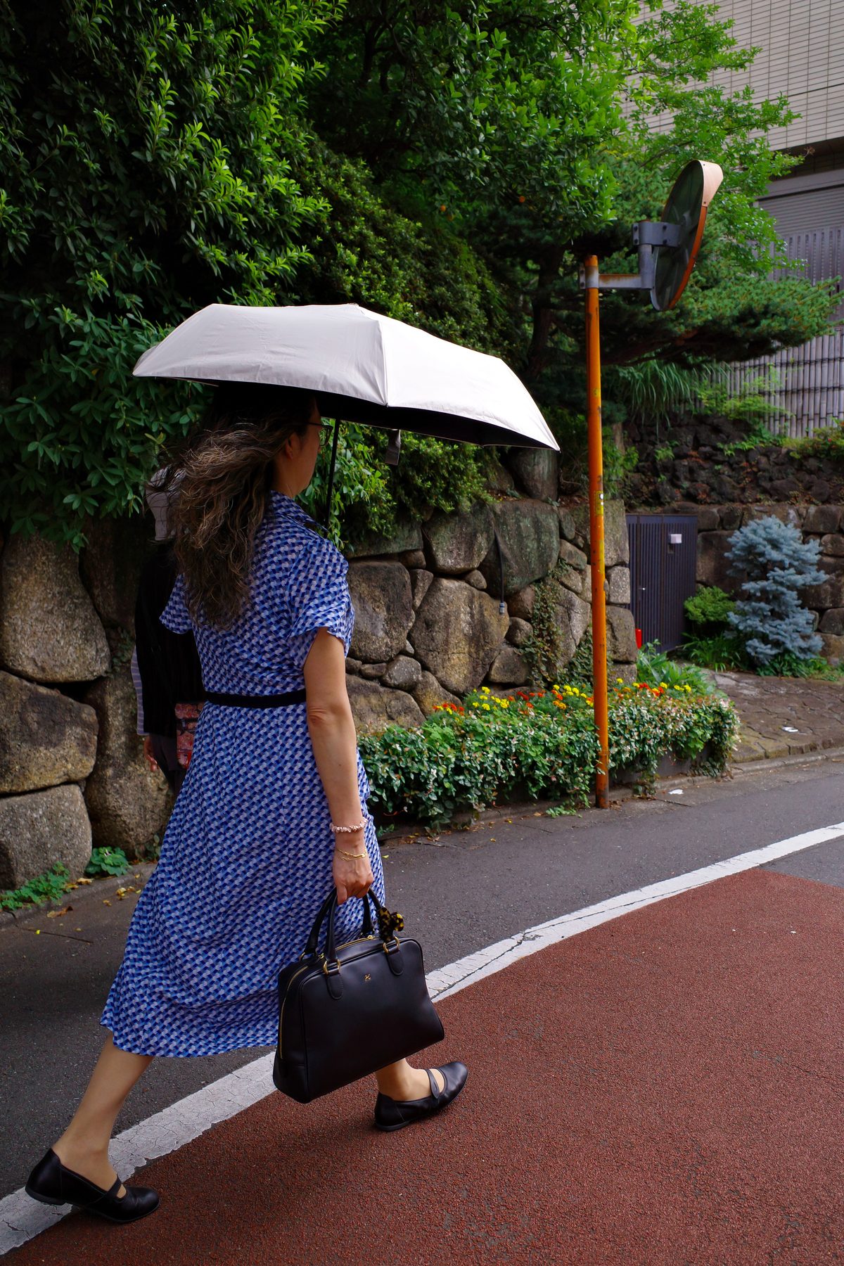 A woman in a blue dress under a parasol