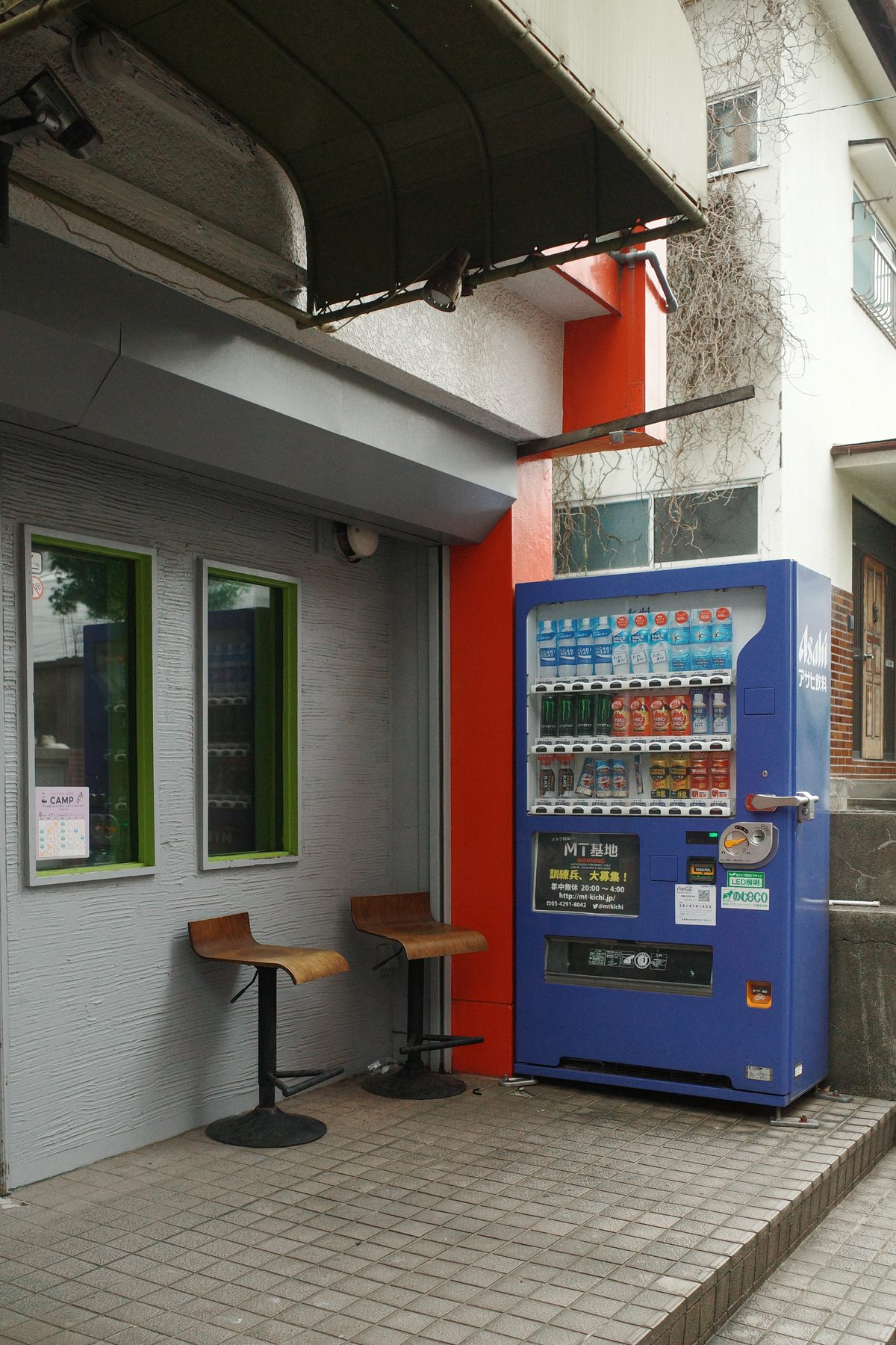A vending machine and two stools