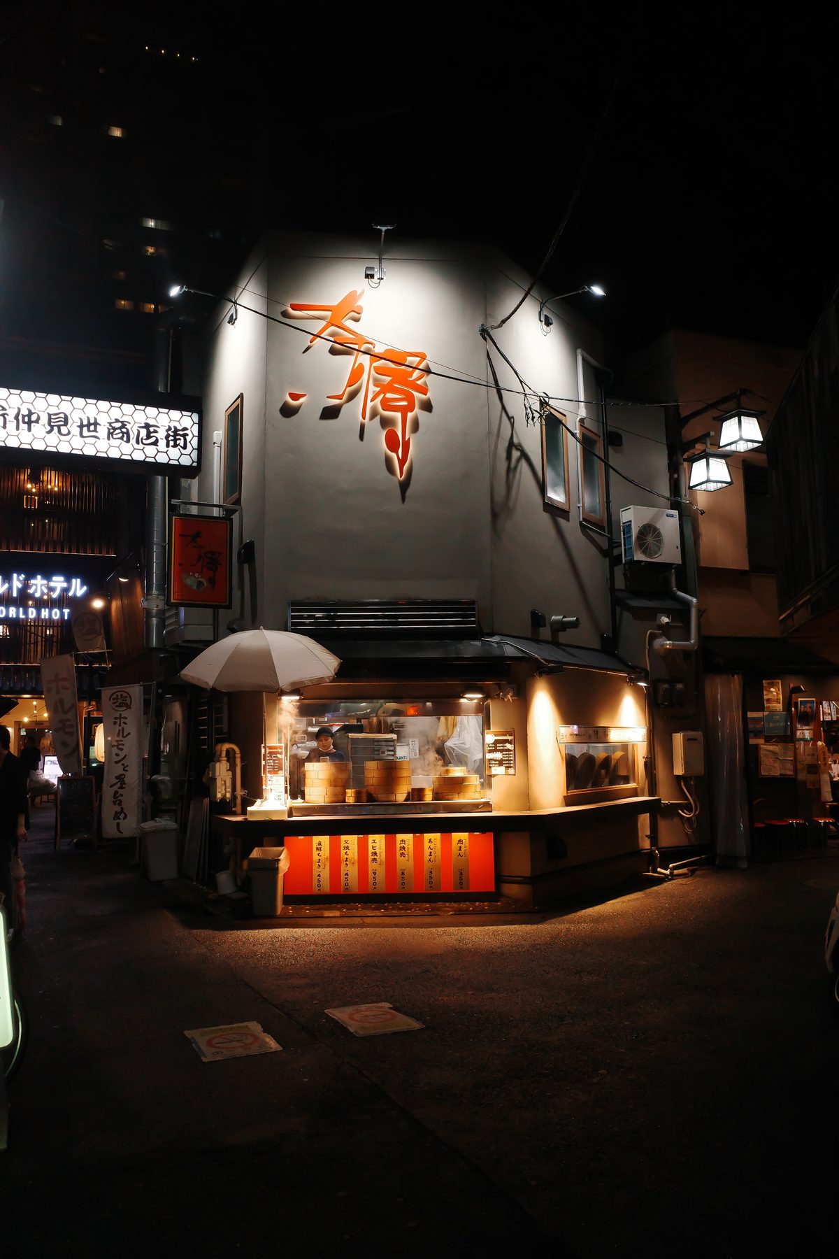 A gyoza stand under a parasol at night